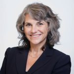Headshot of Michelle Arkin, a woman with a bright smile and dark blazer